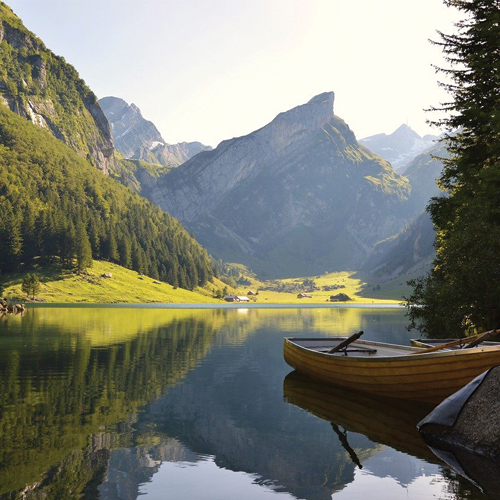 Photo of a lake with mountains and a rowboat on the water