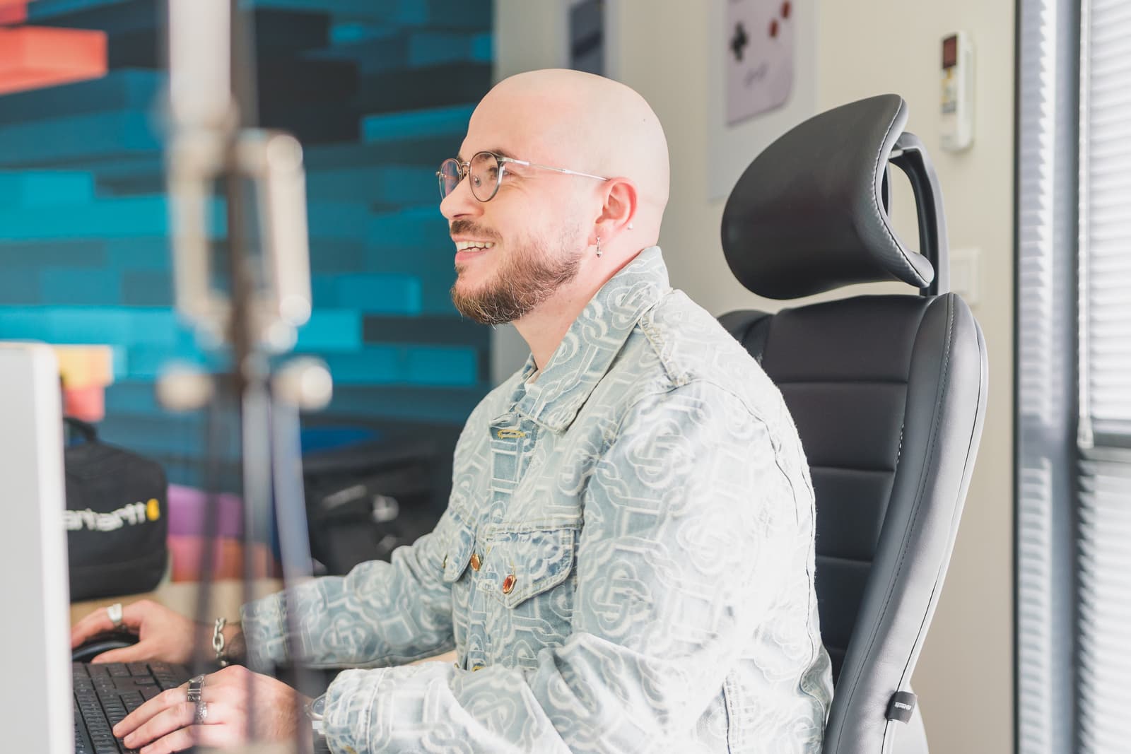 A smiling, bespectacled man working on a computer, transferring data to facilitate the transition of media to the Ephoto Dam Digital Asset Management software.