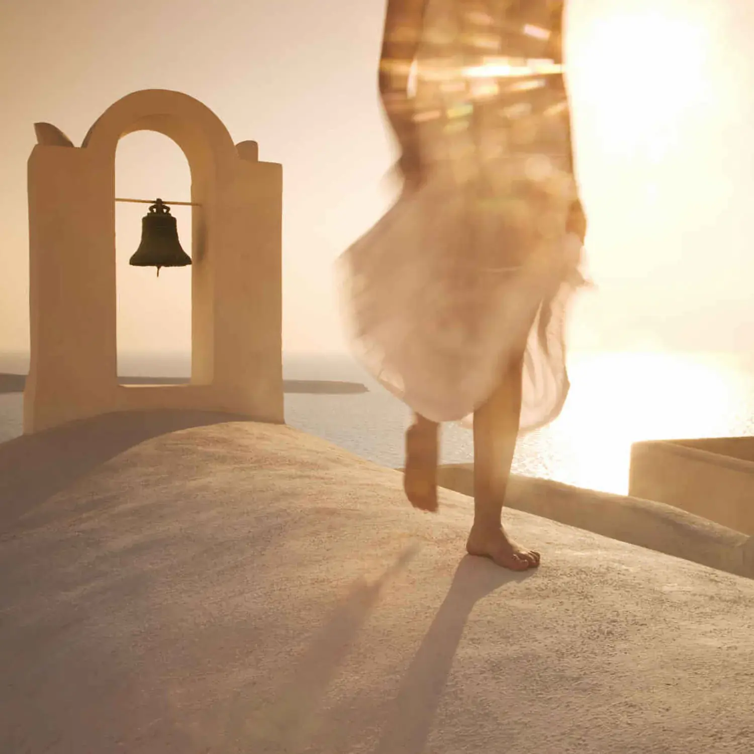 Woman walking on the roof of a white house on the island of Santorini