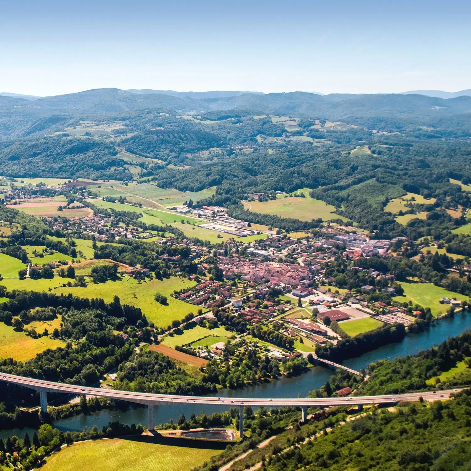 Photo taken from the air showing mountains and a bridge.