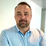 Portrait photo of a man in a blue shirt.