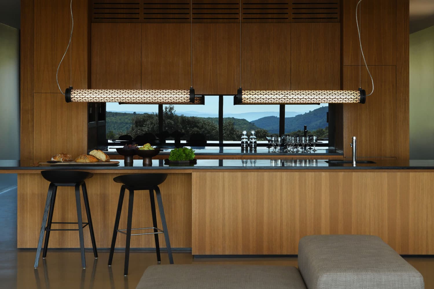 Wooden kitchen in a house with a sea view which has two Sammode brand pendant lights, illuminating the entire worktop.